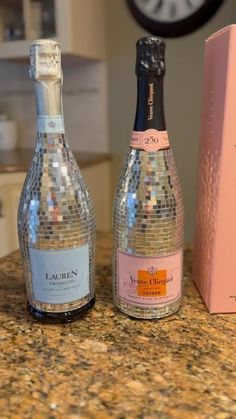 two bottles of wine sitting on top of a counter next to a box and clock