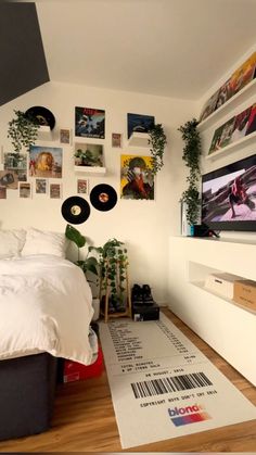 a bed room with a neatly made bed and lots of pictures on the wall above it