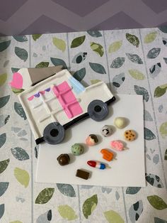 a toy truck is sitting on top of a piece of paper next to some candy