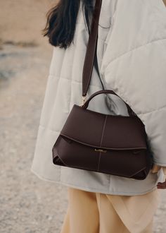 The "Mokki" model showcases the art of folding with its textured leather. The corners are cut to reveal smooth leather for a subtle interplay of textures. The bag’s interior is roomy and divided into compartments, all protected by a flap that features an engraved clasp. With its adjustable shoulder strap held in place by snap hooks, the model smoothly adapts to your movements. Polene Mokki Bag Outfit, Polene Bag, Elegant Watches Women, Micro Bags, Potli Bags, Best Wallet, Classic Bags, Dear Santa, Cute Bags