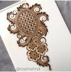 an intricately designed piece of paper on top of a sheet of white paper with brown ink