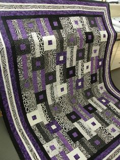 a purple and black quilt sitting on top of a table