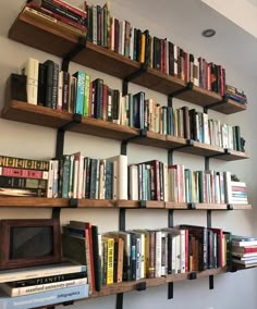 several books are lined up on wooden shelves