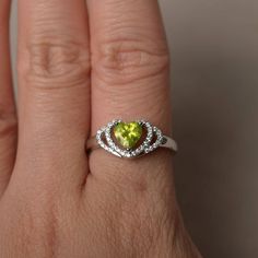 This is a gorgeous handmade creation. Its beauty is its simplicity & Elegance. The 6*6 mm heart cut faceted natural Peridot is crafted in solid sterling silver and with rhodium plated. All item is sent in a beautiful gift box If you have any idea of design your ring,pls contact me directly. You can realize more lovely stuff clicking the link https://www.etsy.com/shop/knightjewelry?refshopsection_shophome_leftnav Please leave the correct address and you phone number for delivering successfull Green Heart Ring For Anniversary, Wedding Ring With Heart Shape For May Birthstone, Green Gemstone Rings With Heart Cut, Green Gemstone Heart Cut Rings, Green Heart Cut Jewelry With Center Stone, Green Heart Cut Center Stone Jewelry, Green Heart Cut Ring For Wedding, Green Heart Cut Rings For Wedding, Green Heart Cut Wedding Rings