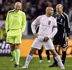 two soccer players standing next to each other on a field