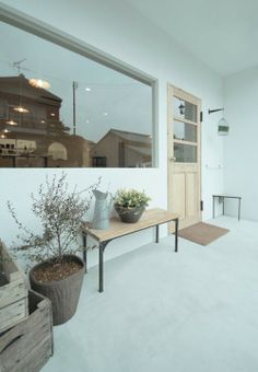 an empty room with a table and potted plants