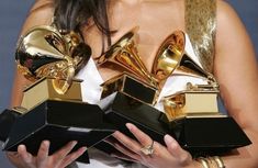 a woman holding several awards in her hands