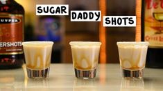 three shot glasses filled with liquid sitting on top of a counter