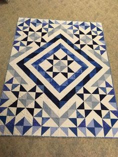 a blue and white quilt on the floor