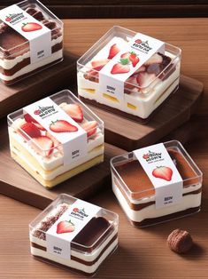 four desserts in plastic containers with strawberries on top