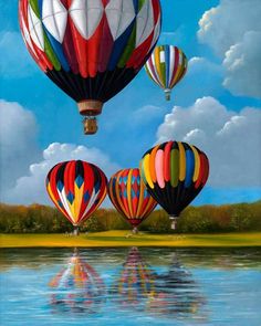 three hot air balloons are flying over the water and reflecting them in the still water