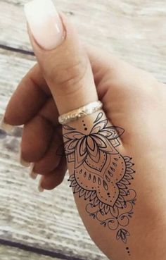 a woman's hand with a henna tattoo on it