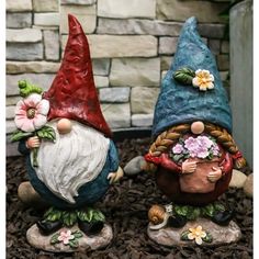 two garden gnomes are sitting on the ground