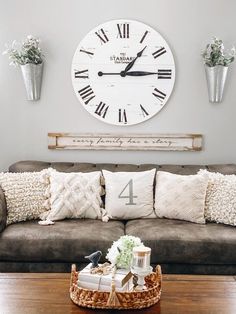 a living room filled with furniture and a large clock on the wall above it's head