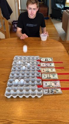 a man sitting at a table with money in an egg carton