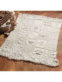 a white blanket sitting on top of a wooden floor next to a potted plant