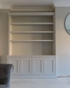 a living room filled with furniture and a large mirror on the wall above it's built - in bookcases