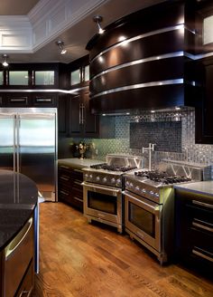 a kitchen with black cabinets and stainless steel appliances