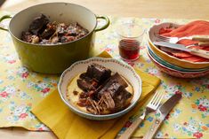 two bowls of food on a table with utensils