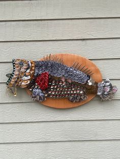 a decorative fish is mounted on the side of a house