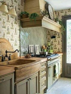 a kitchen with an oven, sink and clock on the wall next to it's windows