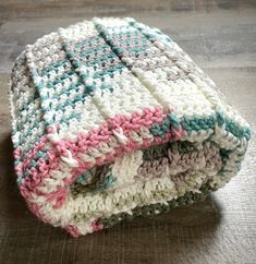 a crocheted blanket laying on top of a wooden floor