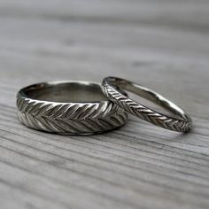 two wedding rings sitting on top of a wooden table