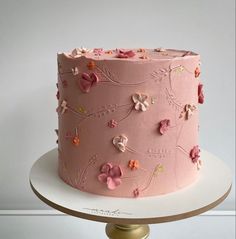 a pink frosted cake with flowers on it