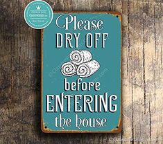 a sign on a wooden wall that says please dry off before entering the house with rolls