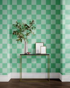 a green and white checkered wall with a plant on a table