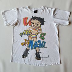 "An awesome Betty Boop tee from the 90s with a Changes tag. It's 2 sided and 100% cotton. It's in great condition, not much wear but does have minor marks on the sleeve and faint stains on the front below the graphic, which is not noticeable. Shoulder - 18.5\" Chest - 22\" Length - 27\" Sleeve - 8\"" Betty Boop Graphic Tee, Vintage Betty Boop Shirt, Cheap Pop Culture Graphic T-shirt, Betty Boop Shirt Outfit, 90s Inspired Multicolor T-shirt For Streetwear, 90s Style Multicolor Tops For Fan Merchandise, Graphic T-shirts, 90s Graphic Tees, Betty Boop Shirt