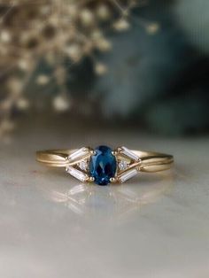 a close up of a ring with a blue stone and two white stones on it