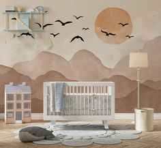 a baby's room with mountains and birds painted on the wall, including a crib