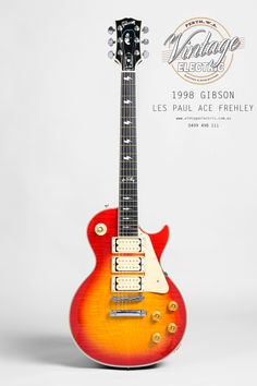 an orange and red electric guitar sitting on top of a white background with the words vintage gibson les paul ace frieley