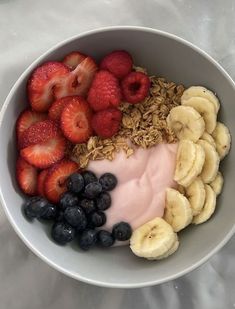 a bowl filled with fruit and yogurt on top of a white tablecloth