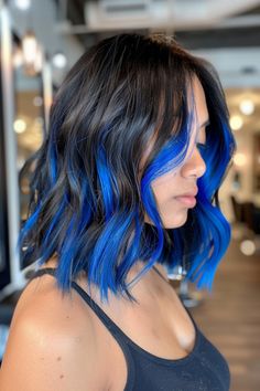 Woman with shoulder-length black hair featuring vibrant blue highlights. Short Blue Hair Highlights, Bangs And Brown Hair, Balayage Hair For Brunettes, Blue Hair Bangs, Brown Hair With Blue Highlights, Blue Balayage Hair, Blue Hair Underneath, Blue And Brown Hair