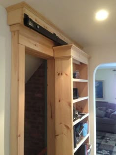 a room with a bookcase and couch in it next to a wall mounted mirror