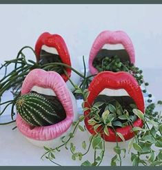 three fake lips with plants growing out of them