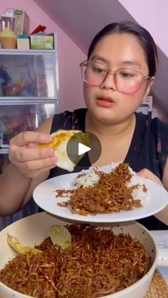 a woman eating food from a bowl on top of a table