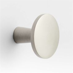 a white door knob with a round handle on a white wall, in the middle of an empty room