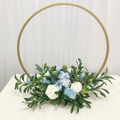 a white and blue flower arrangement sitting on top of a table