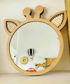 a mirror that is on the side of a shelf with an animal head in it