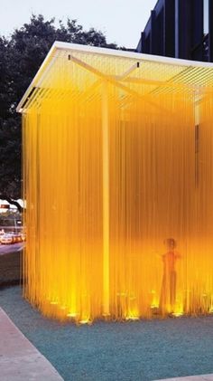 an outdoor shower with yellow curtains in front of a building