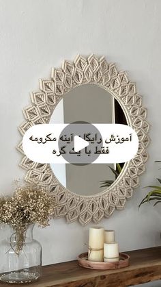 a mirror that is on the wall above a table with candles and flowers in front of it