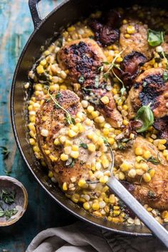 a skillet filled with chicken and corn