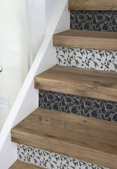 the stairs are decorated with black and white tiles on them, along with wood flooring