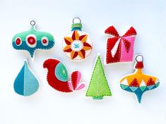 felt ornaments are arranged on a white surface