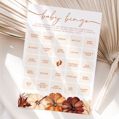 a baby shower game with pumpkins and leaves on the table next to a fan