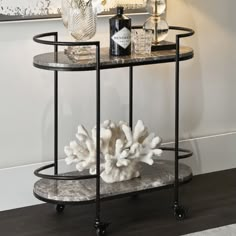 a black and white marble topped table with wine bottles on it next to a painting