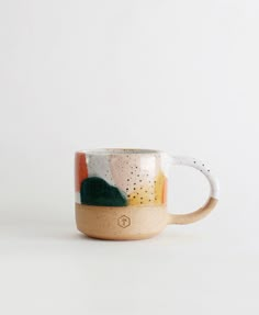 a coffee cup with an abstract design on the outside and inside, sitting on a white surface